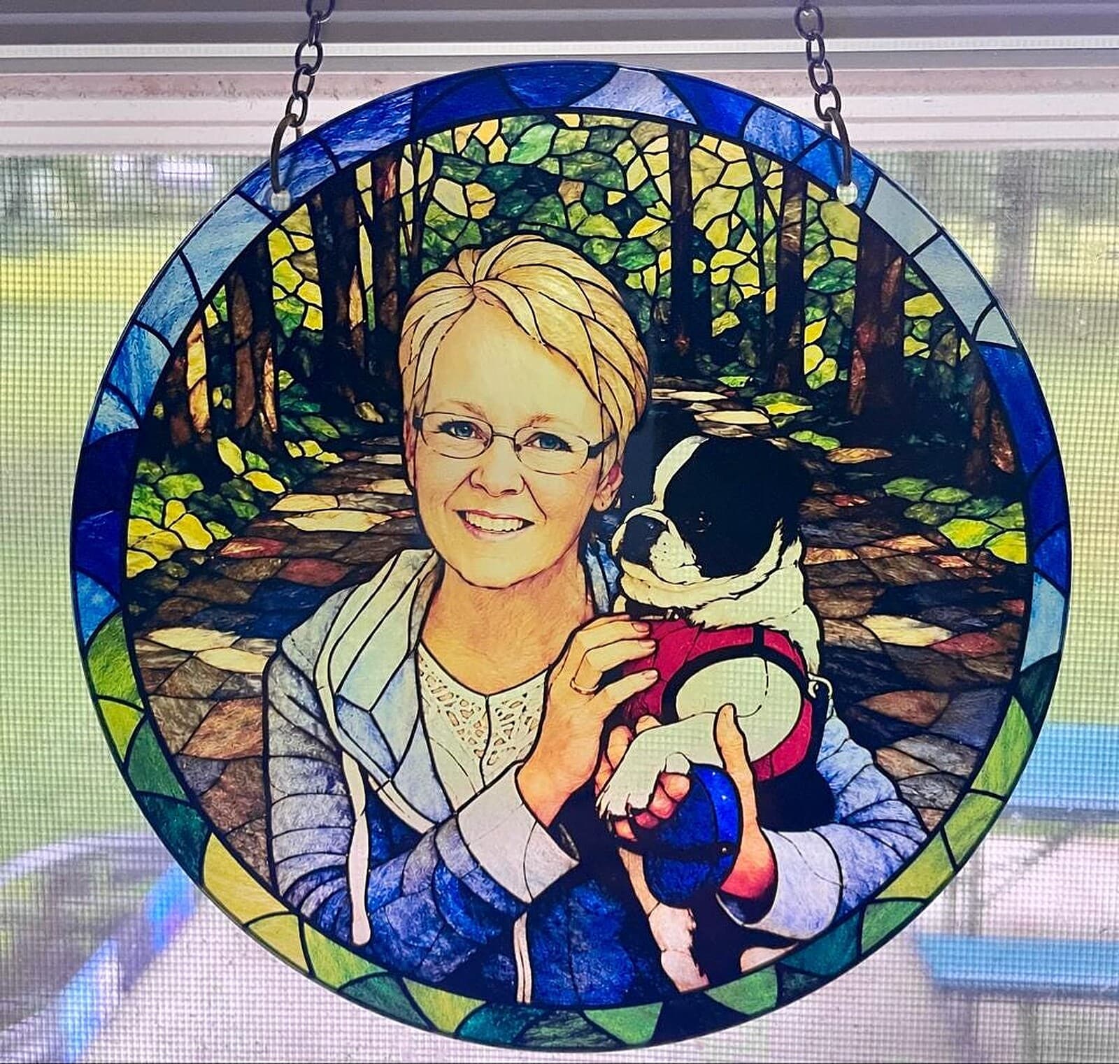 Stained glass style memorial portrait of a woman holding her dog, glowing in a window